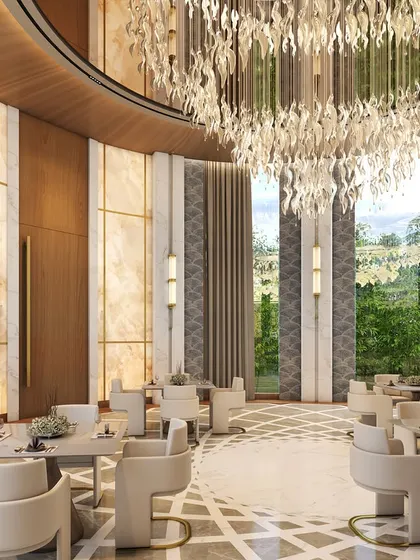 The lavish dining area of the House of Abhinandan Lodha's clubhouse in Alibaug. Greeted by pristine white marble floors and a breathtaking crystal chandelier, this space narrates a tale of opulence and curated luxury.