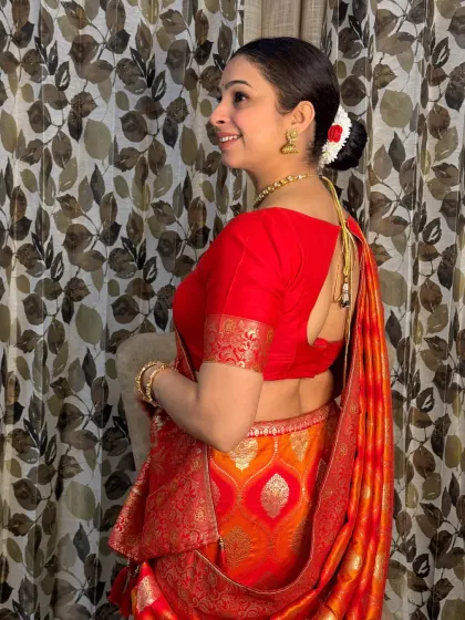 This view highlights the elegant back blouse design and the traditional hairstyle. The makeup ensures a flawless look from every angle, perfect for photographs.