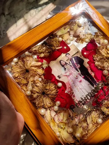 The sunlight catching a 25th-anniversary frame, highlighting the rich colors of the preserved red and yellow roses. A truly radiant tribute to a silver jubilee.
