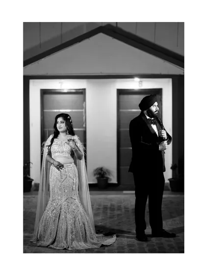 A stylish black and white portrait of the couple on their engagement day. The composition creates a sense of modern elegance and drama, focusing on their fashionable attire and confident poses.