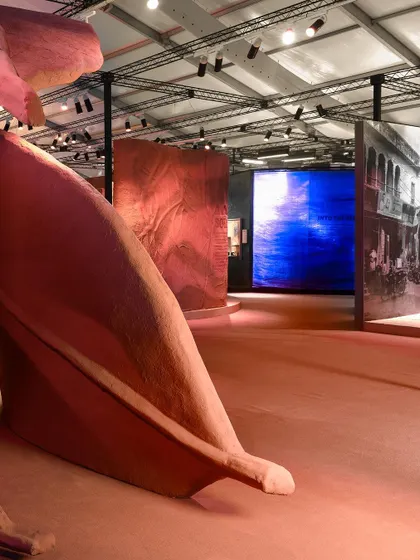 An expansive view of the 'Terra' installation, showing how the giant leaf sculptures interact with light and surrounding digital displays. The piece creates a metaphorical landscape that feels both familiar and otherworldly.