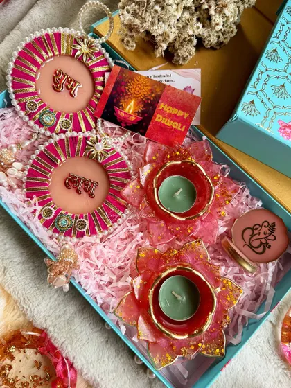 My Diwali collection is here. This hamper includes pink "Shubh Labh" hangings, lotus diyas, and a Ganesha-themed container.