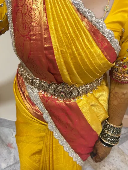A close-up of a right-side pallu drape on a yellow and red silk saree. This is a popular and trendy style that I can create flawlessly for any occasion.