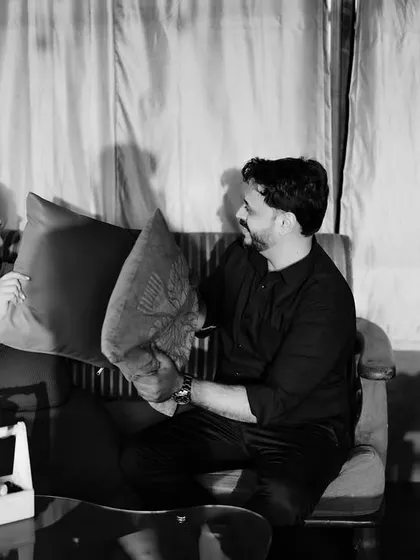 A fun and playful black and white shot of the couple having a pillow fight on the sofa. It captures their lighthearted and joyful connection.