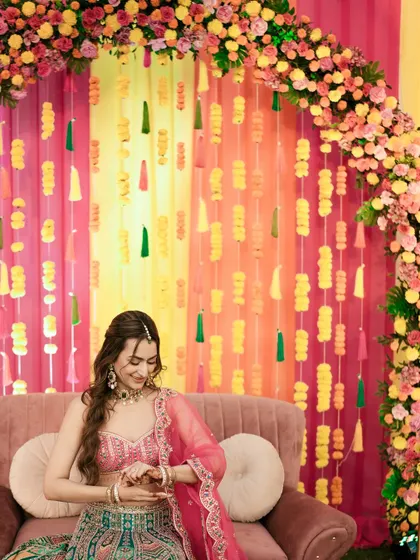 A quiet moment for the bride on the Sangeet stage, checking her watch with a smile.