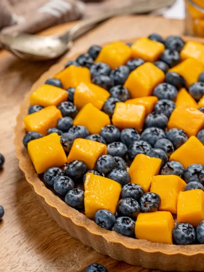 A close-up of the unconventional but delicious pairing of mango and blueberry on my signature tart. It's a flavor combination you have to try to believe.