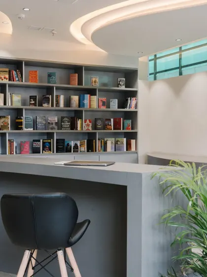 The curved form of the reception desk is echoed in the ceiling design, creating a cohesive and fluid entrance space.