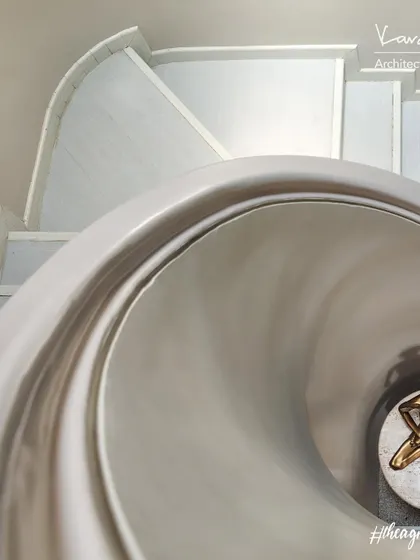 A close-up of the "Cinderella staircase." The smooth, flowing curves of the handrail and the clean white marble steps create a feeling of elegance and peace.