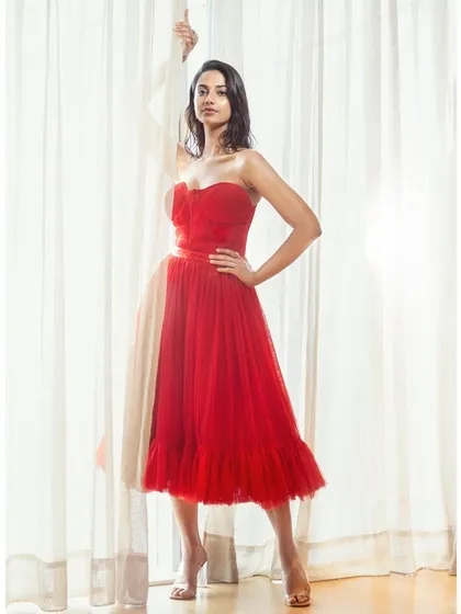 This strapless red tulle dress creates a classic, romantic silhouette. The sweetheart neckline and full skirt are perfect for a celebratory occasion.