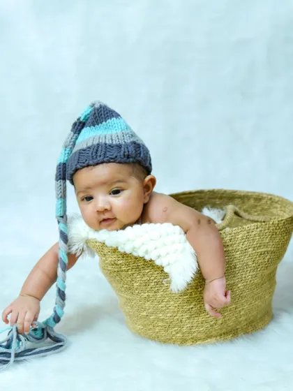 Hello there, little one. We capture those moments when your baby starts to interact with the world, like playing with their cute, long hat.