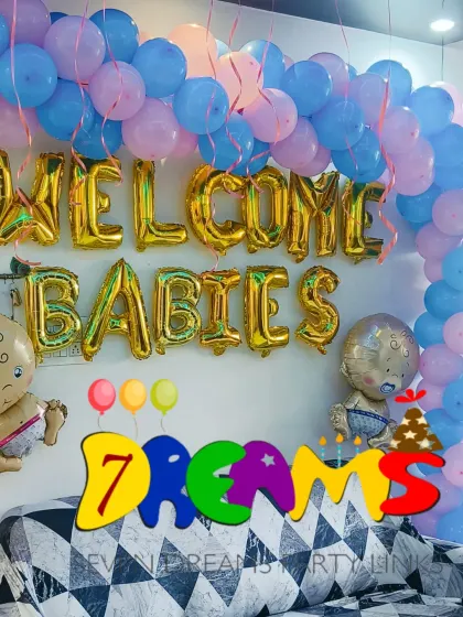For a sweet and simple celebration at home, I offer welcome home decorations. This setup for twins features "WELCOME BABIES" foil balloons, cute baby-shaped foils, and a pink and blue balloon arch over the family sofa.