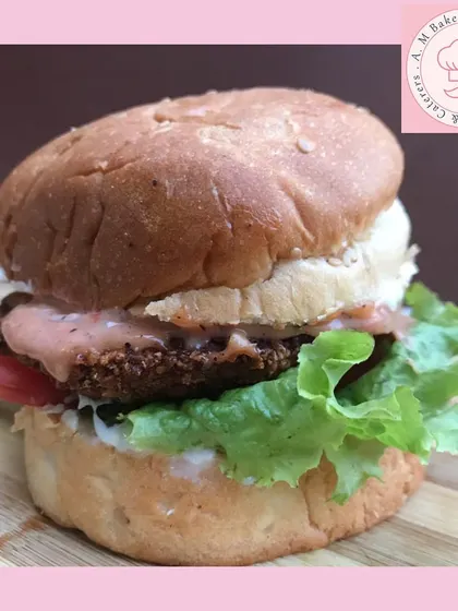 Here’s a close-up of my mini chicken burger. I build it with a juicy patty, fresh lettuce, and our special sauce on a soft bun. It's a huge hit in the kids' party boxes.