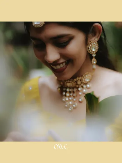 A close-up of the bride's joyful smile and beautiful jewellery during her Haldi ceremony.