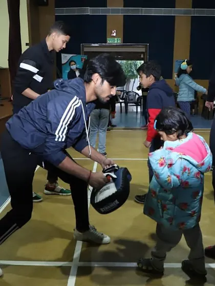 Even our youngest students get involved. Here, an instructor patiently teaches a young child the basics of striking.