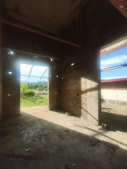 Sunlight streams through the open roof, casting strong shadows and highlighting the volume of the space.