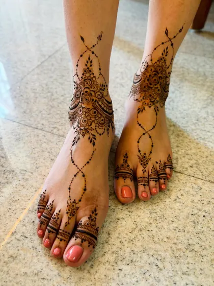A minimal Arabic-style feet mehendi, with a graceful pattern flowing from the ankle down to the toes.