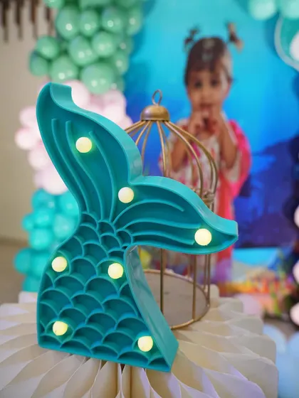 A mermaid tail marquee light, a perfect little prop for an under-the-sea theme.