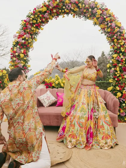 A playful moment between the couple during their Haldi carnival. Their coordinated printed outfits add to the fun and festive atmosphere.
