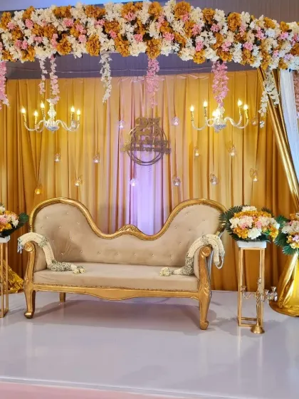 A classic and elegant stage for a 25th wedding anniversary. I used gold drapery, crystal chandeliers, and lush floral arrangements to create a royal look, complete with a vintage-style chaise lounge for photos.