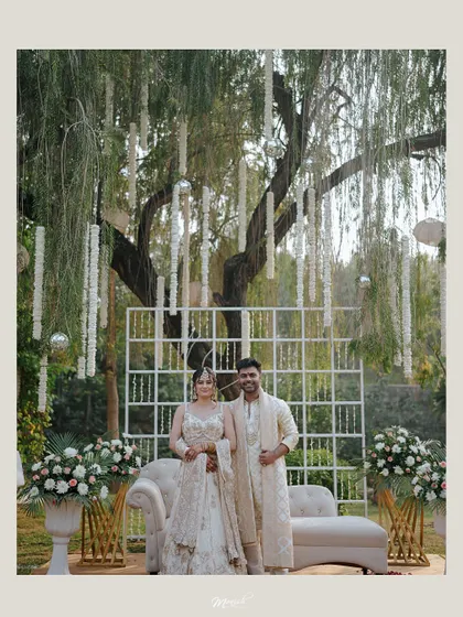 A grand portrait of the engaged couple under a beautifully decorated tree, looking regal and happy.