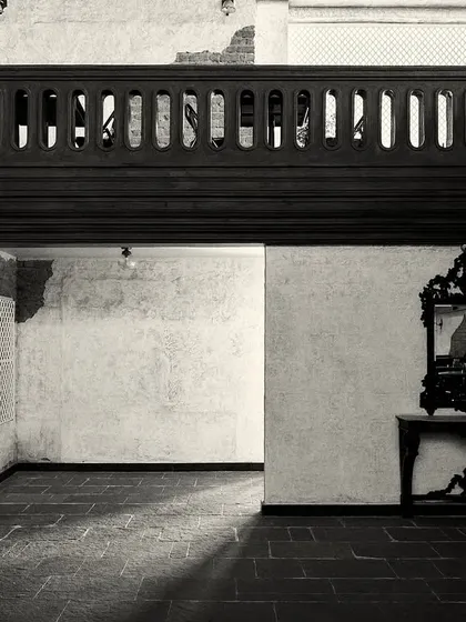 An empty corner of the room, where light and shadow play across the stone floor. The design uses negative space to create a sense of calm.