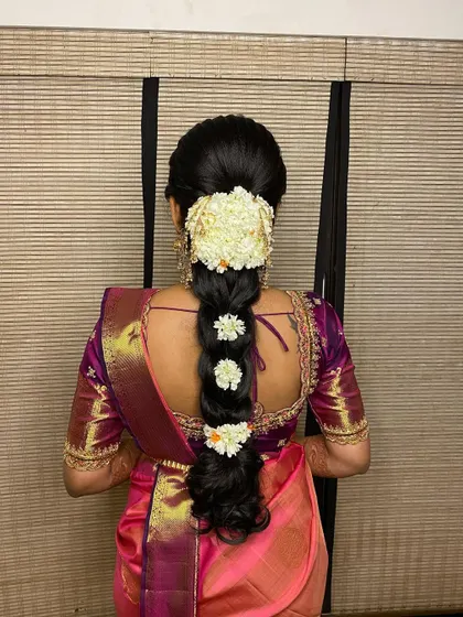 A beautiful messy braid for an engagement, styled with a jasmine gajra and smaller flowers tucked into the plait for a delicate finish.