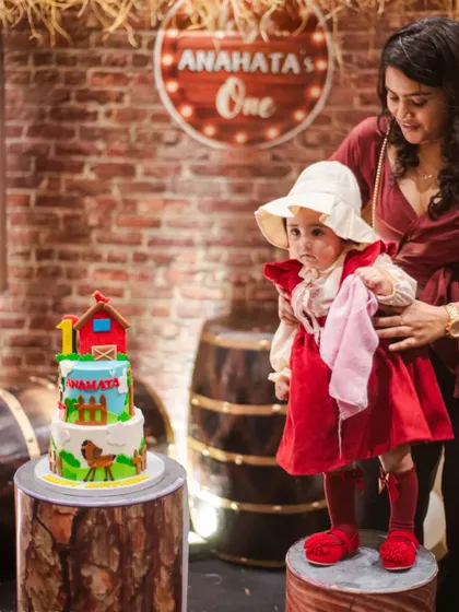 The birthday girl and her farm-themed cake, perfectly matching the rustic barnyard decor.