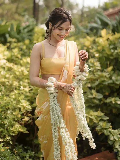 A close-up of the bride with her floral kaleeras, showing the delicate details of the flowers.