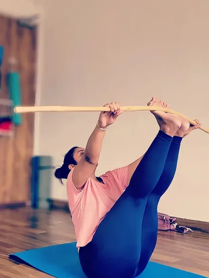 Using a stick to deepen the stretch in this seated pose. The stick acts as an extension of the arms, helping to improve flexibility.