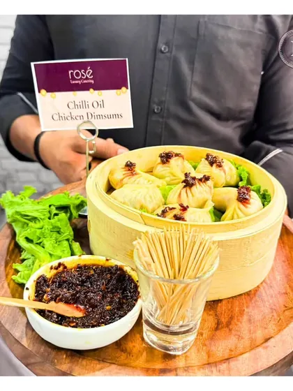Our Chilli Oil Chicken Dimsums are a fusion of classic steaming and bold, spicy flavors. Served in a traditional bamboo basket with our house-made chili oil, they are a guaranteed crowd-pleaser.