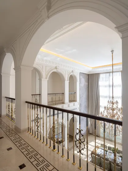 A view from the upper gallery of The Ivory Royale, looking down into the double-height dining area. The repeating arches create a beautiful rhythm, while the grand chandelier serves as a stunning centerpiece.
