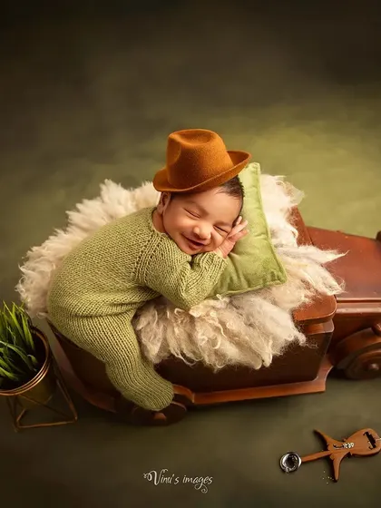 My sessions can be as creative as you wish. Here, a sweet sleeping baby dreams of adventure in a vintage-style truck prop, complete with a cozy pillow and a touch of greenery. This shows how we can incorporate fun themes into your newborn's first photoshoot.