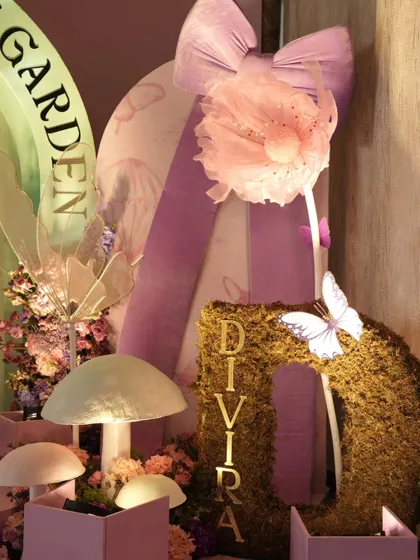 A close-up of the enchanted garden decor, showing a moss-covered initial, glowing mushrooms, and delicate fairy wings. These details bring the magical theme to life.