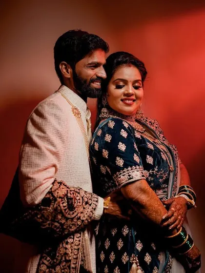 A warm and loving portrait using dramatic red backlighting. This technique creates a bold silhouette and highlights the couple's embrace.