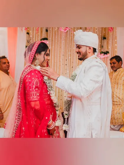 A beautiful moment during the Varmala ceremony, where the groom places the garland on the bride.