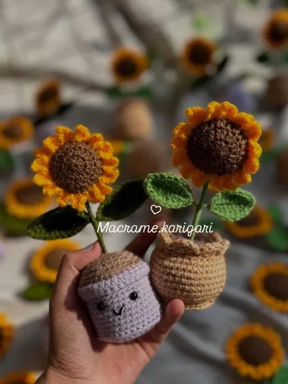 Holding two of our smiling sunflower pots. We offer the pots in different colors like lilac and natural brown. They are a small, joyful piece of handmade art.
