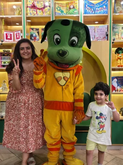 A mother and son share a happy moment with our mascot, Tinga Dojo. We believe in creating joyful experiences for the whole family.