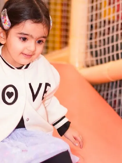 A young girl gets ready to go down one of the slides in our multi-level play structure.