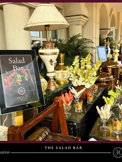 A fresh and inviting salad bar, beautifully arranged with vegetable sticks in martini glasses and various greens. This setup offers a healthy and customizable option for your guests.