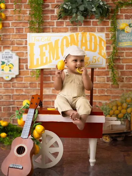 Taking a break to sample the goods. This little one is enjoying a lemon at his stand, creating an adorable and funny moment.