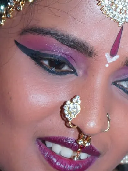 An extreme close-up focusing on the detailed eye makeup, which is a critical part of the dancer's expressive performance.