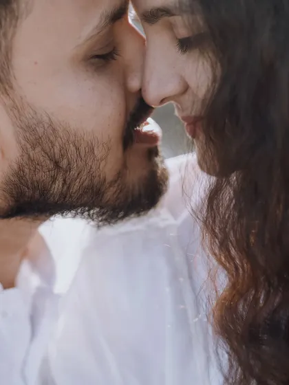 An intimate close-up capturing a near-kiss, full of anticipation and emotion. The soft lighting enhances the romantic and candid feel of the moment.