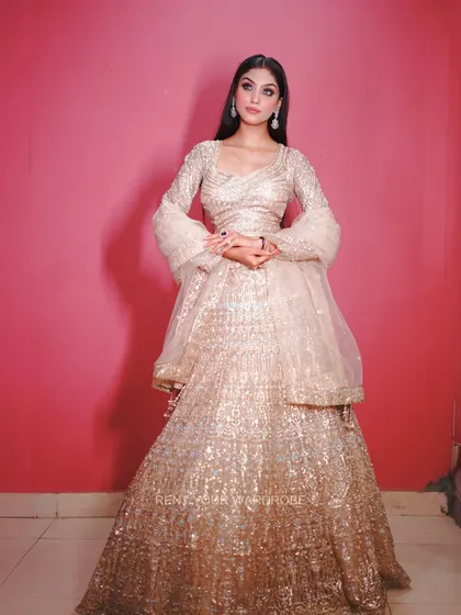 A full-length view of the golden lehenga, showing its beautiful shine and flattering fit.