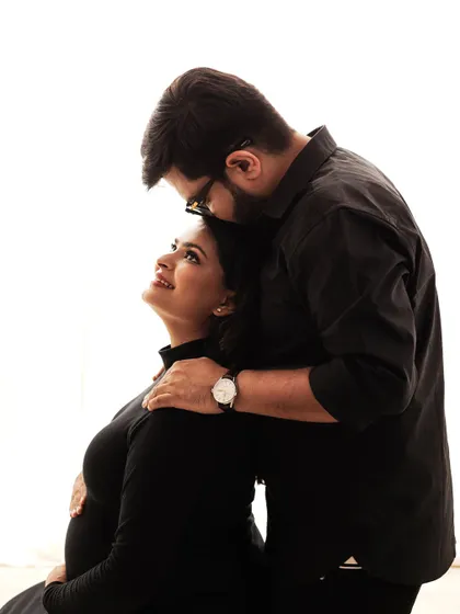 An intimate and loving embrace during a minimalist maternity shoot. The focus is purely on the couple's connection and the beauty of the moment.