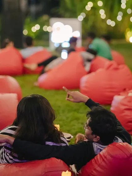 A couple enjoying a movie night together, pointing at the screen. It's a perfect date night idea.