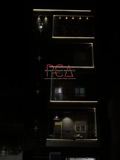 A partial night view of The Cursive Abode, focusing on the lower floors and the subtle illumination that creates an inviting ambiance.