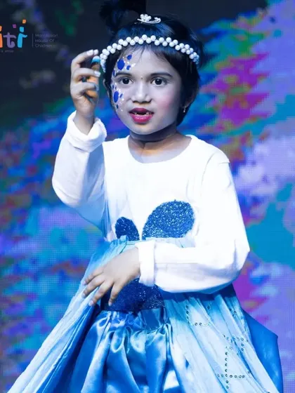 A close-up of a performer from the Neera dance, her face painted with beautiful blue water-like swirls.
