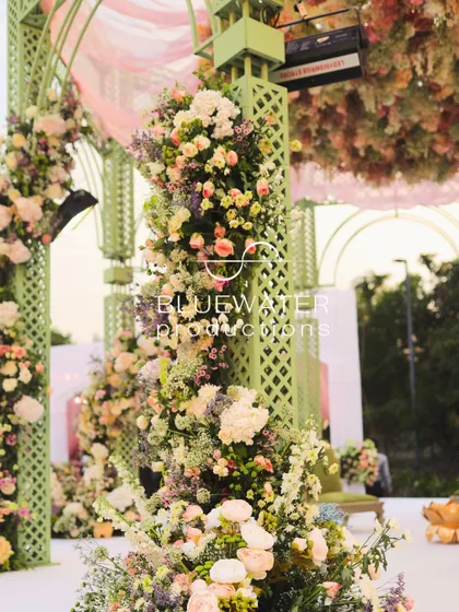 A close-up of the floral arrangements on the mandap pillars, showing the intricate layering of different flowers and textures.