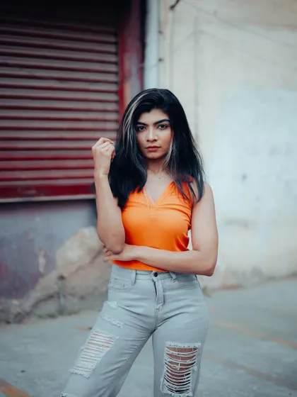 A strong and confident street portrait. The model's direct gaze and powerful pose against the urban backdrop create a bold and memorable shot.