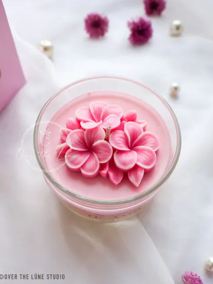 A close-up of one of the pink Plumeria jar candles. The two-toned petals add so much depth and realism to the flower.